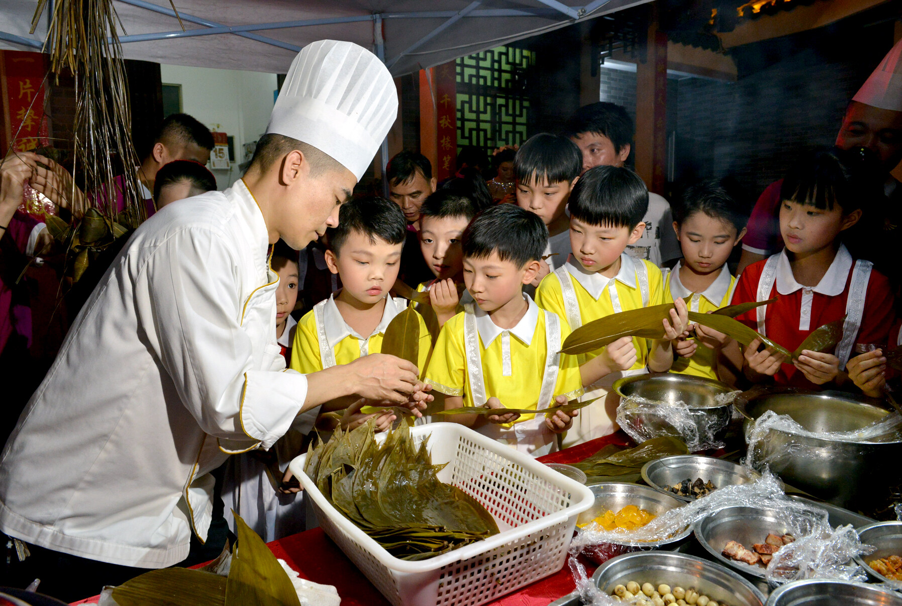 现场展示粽子制作过程，青少年朋友体验包粽子。