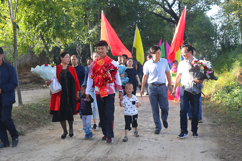 王凯华回到村里,村民们夹道欢迎.